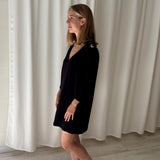 Vestido negro escote en V con ojales dorados en hombros ba&sh