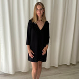 Vestido negro escote en V con ojales dorados en hombros ba&sh