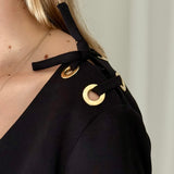Vestido negro escote en V con ojales dorados en hombros ba&sh